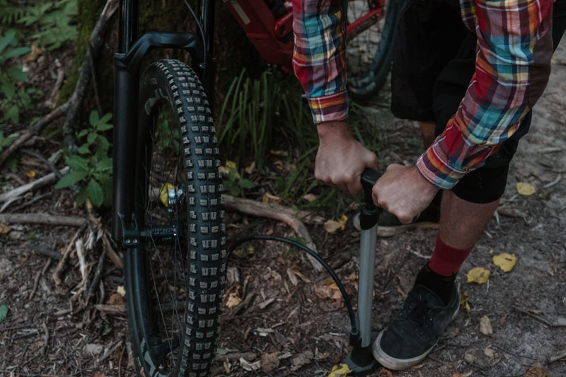 a man putting air into a bicycle tire