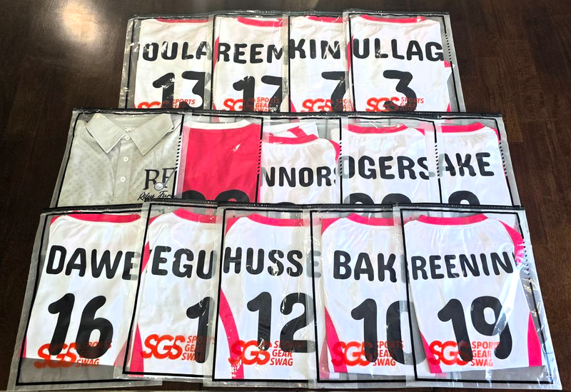 a set of custom team uniforms in packaging on a wooden floor