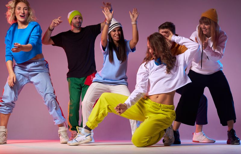 a dance team in front of a purple wall