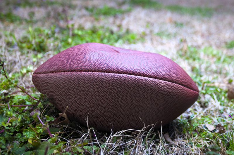 a deflated American football on grass