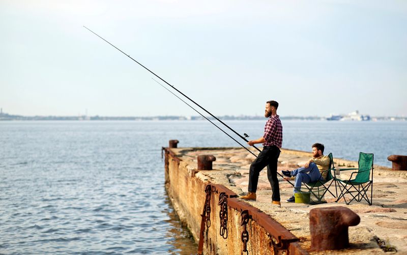 a man fishing from a pier into the ocean