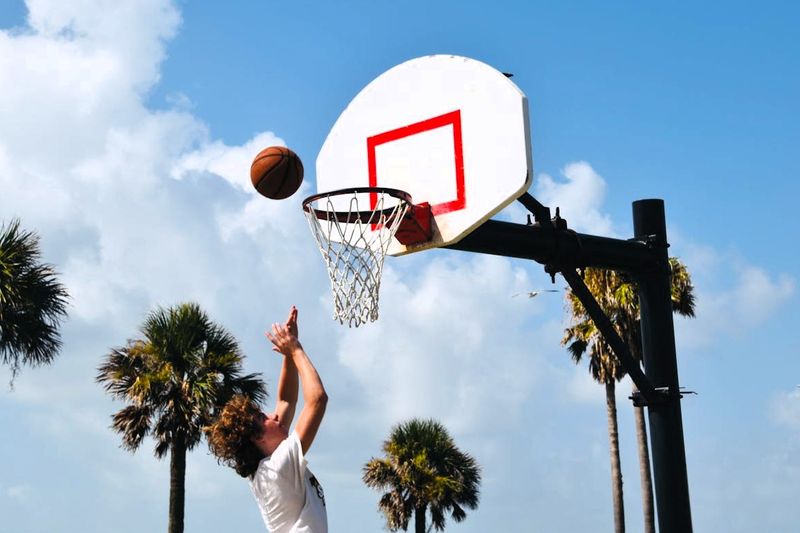 a young male taking a close basketball shot on an outdoor basketball court