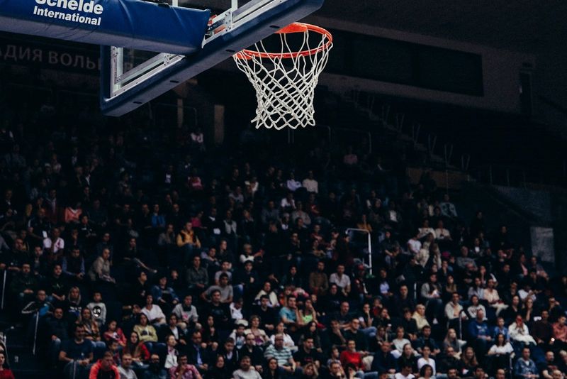 a close up of a basketball net with a crowd of fans in the stands behind it