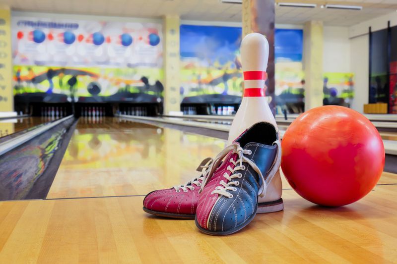 a pair of bowling shoes next to a bowling bowl and bowling pin