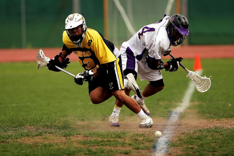 two lacrosse players on a field