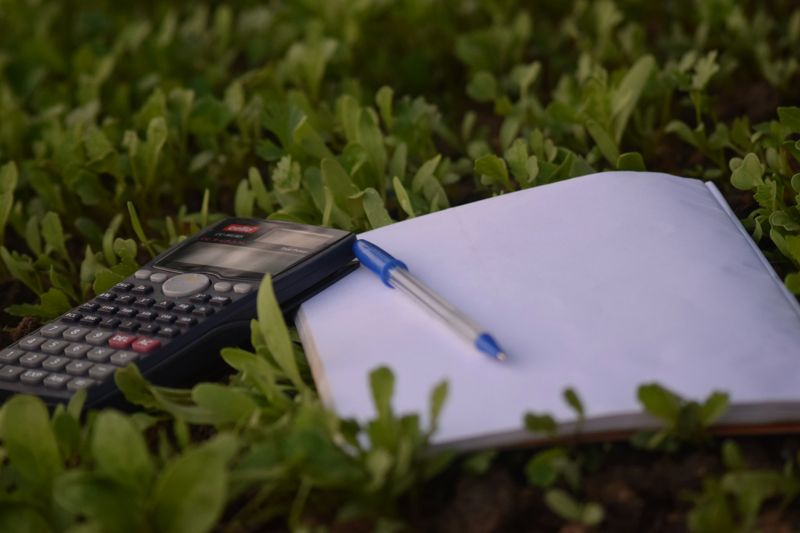 a calculator and notepad on grass