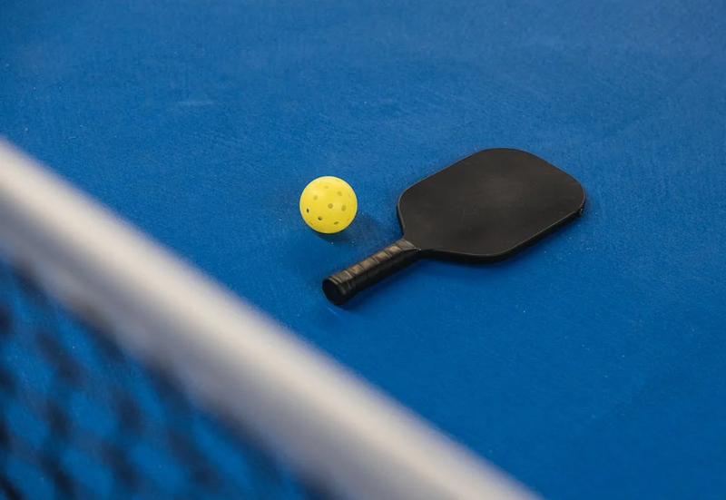 a pickleball racket and ball on a court