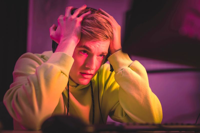 a frustrated esports player with his hands on his head