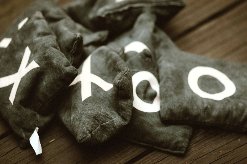 a set of cornhole bags with X and O on various bags