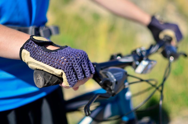 a cyclist holding the handlebars wearing cycling gloves
