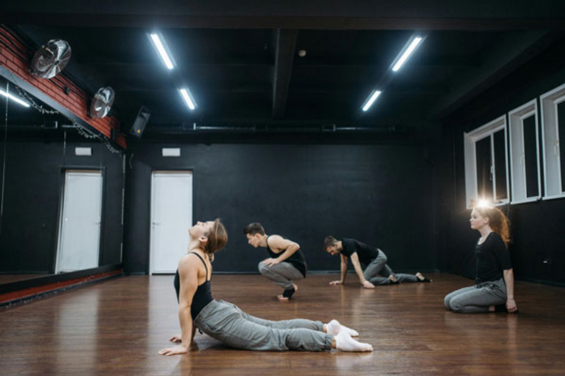 dancers stretching on wooden floor in studio