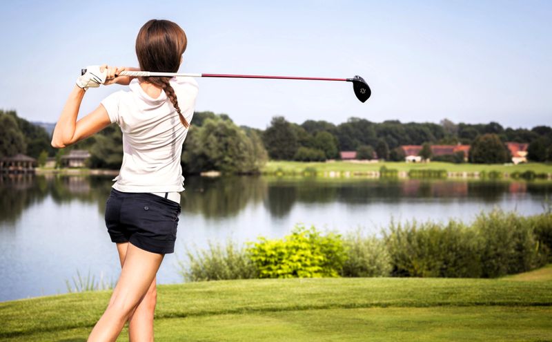 a youth female golfer finishing a golf swing