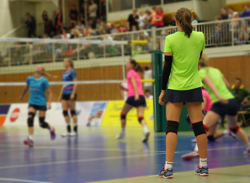 a volleyball game on a blue volleyball court