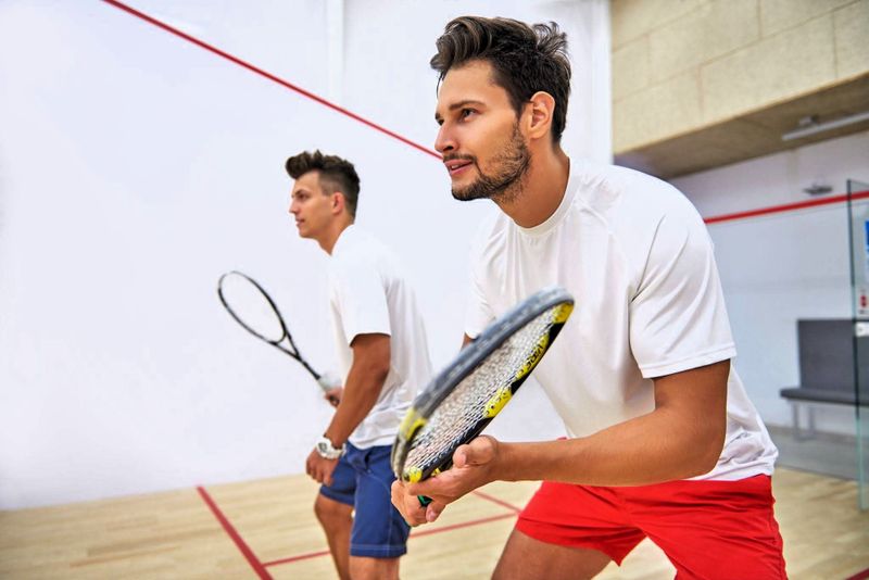 two competing squash players playing squash