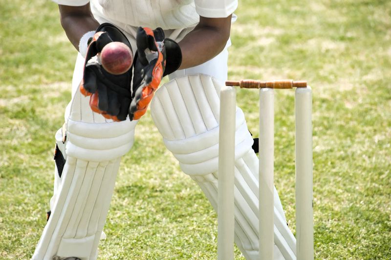 a cricket player about to catch a cricket ball