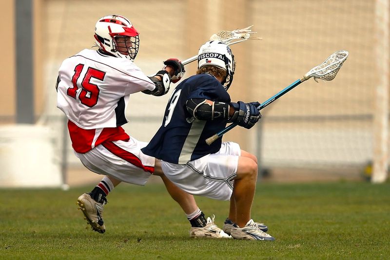 two lacrosse players playing lacrosse