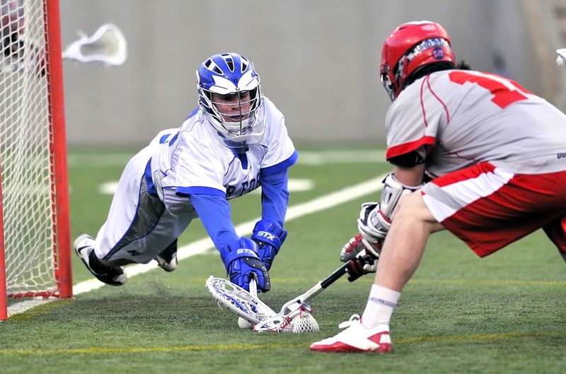 lacrosse players battling for the lacrosse ball