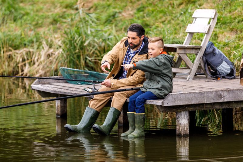 a father and son fishing on a pier