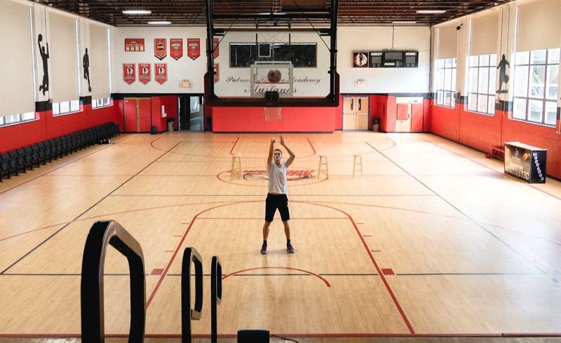 a basketball player taking free throws alone on an indoor basketball court