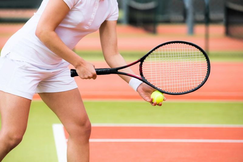 a female tennis player preparing to serve