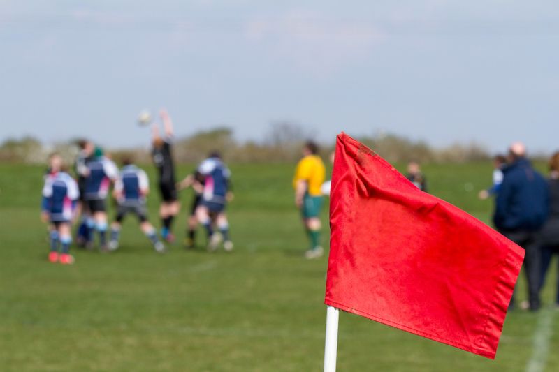 a red soccer corner flag in front of a soccer match