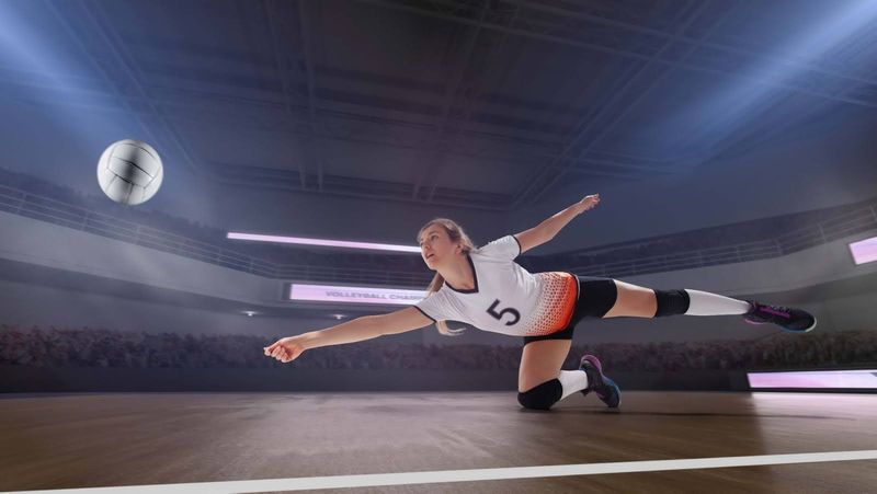 a volleyball player stretching to hit the ball