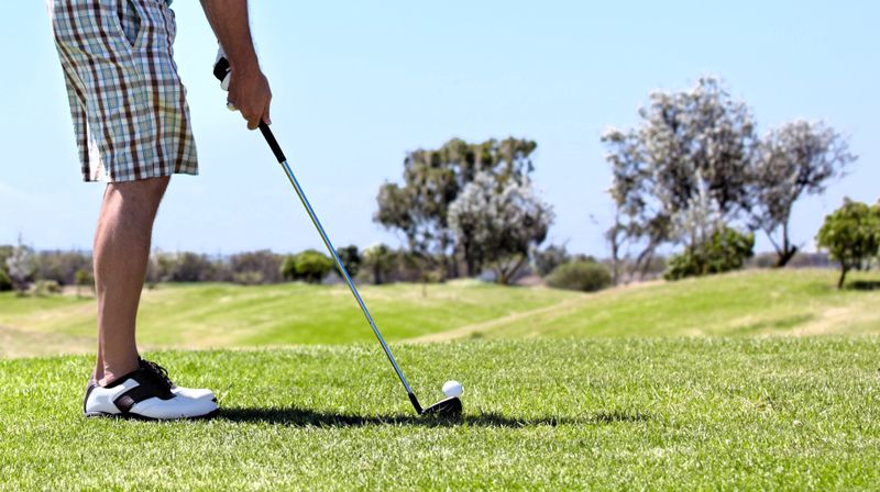a male adult golfer preparing for a pitch shot