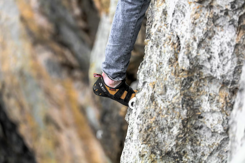 a close up of a person climbing while wearing climbing shoes