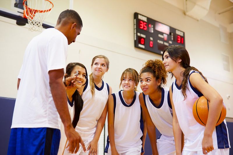 a basketball coach speaking with a youth female basketball team