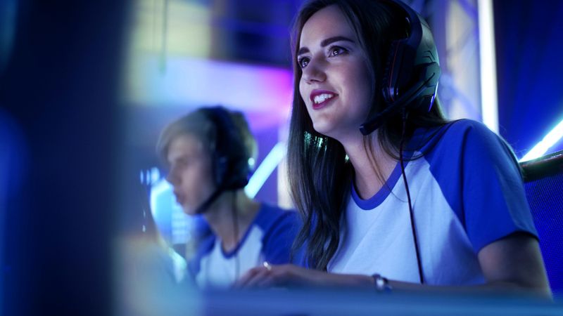 two esports players sitting in front a computer screens