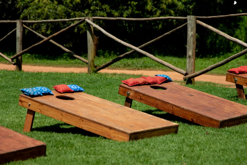 a cornhole board with red and blue cornhole bags lying on the board