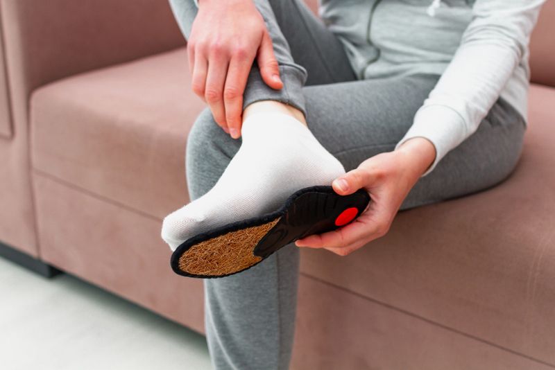 a women putting a sports insole on the bottom of her foot for sizing