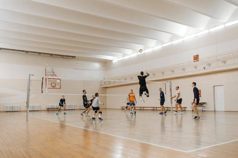 A man hitting a volleyball over the net