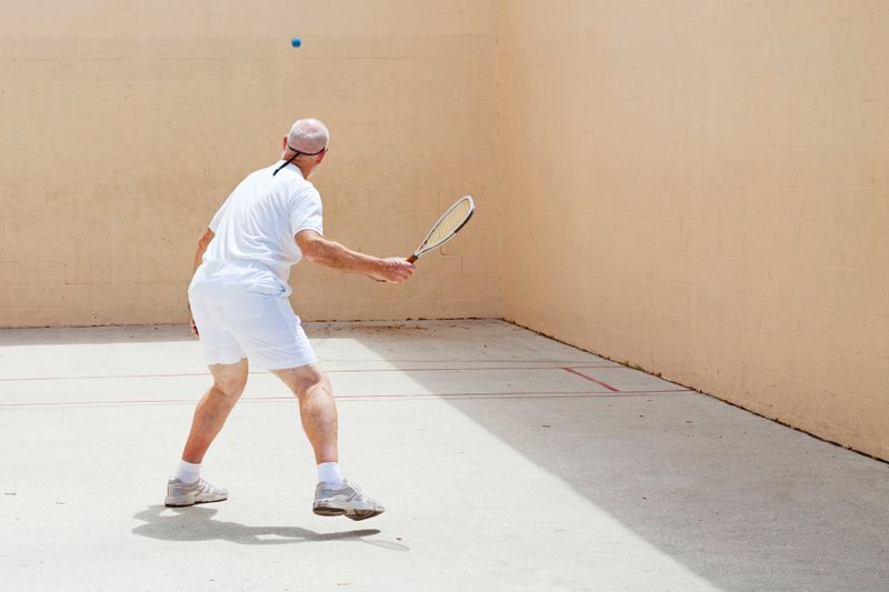 an adult male practicing racquetball solo