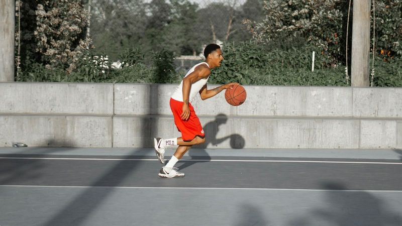 a basketball player dribbling a basketball