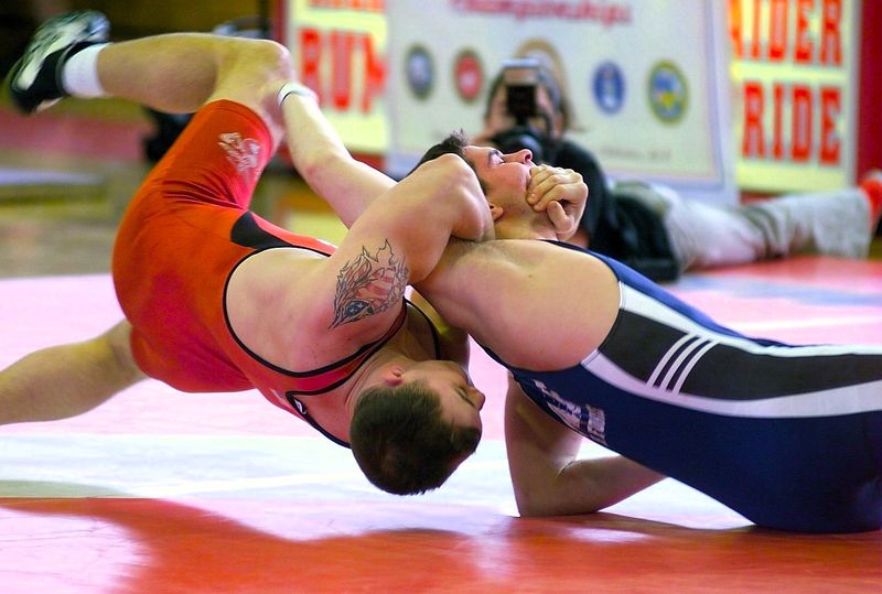 two wrestlers grappling on a wrestling mat