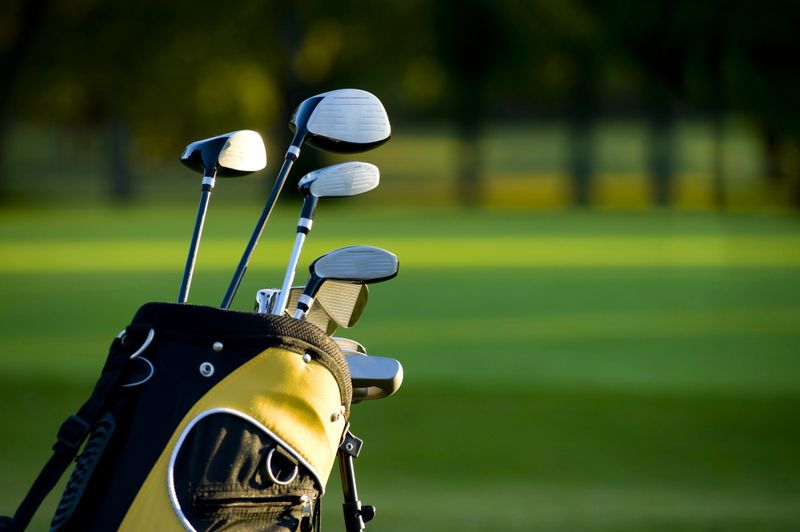 a set of golf clubs in a yellow golf club bag