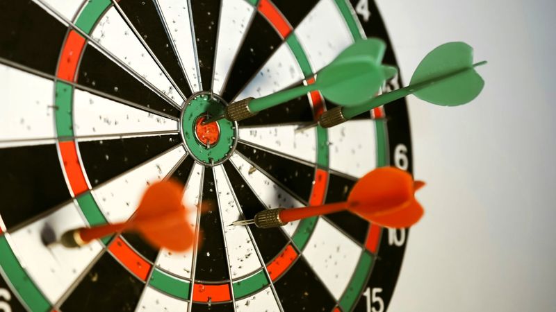 green and red darts in a dart board