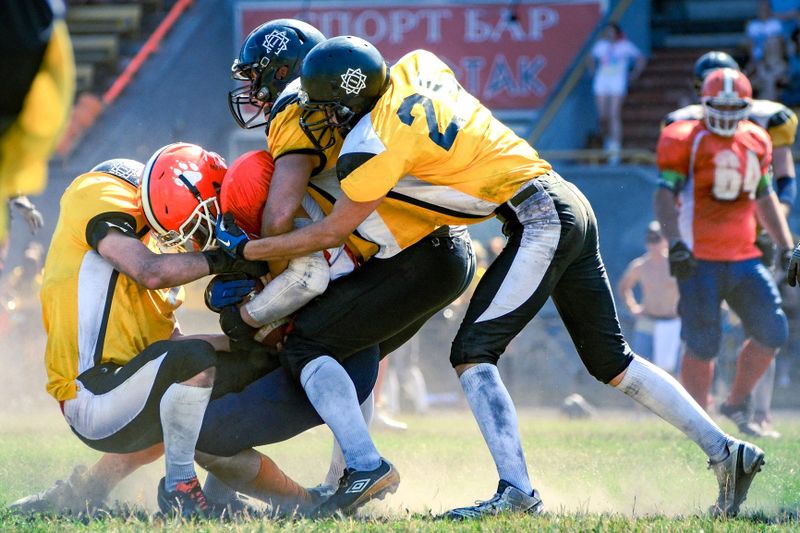 Football players tackling an opponent