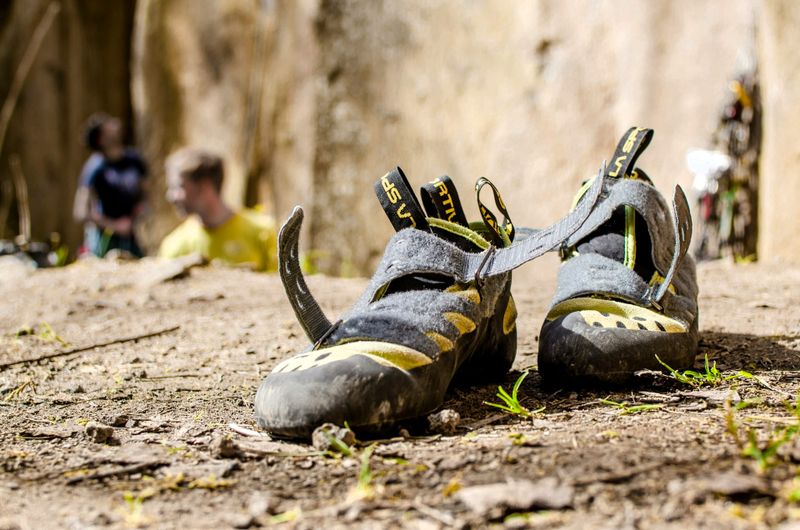 a pair of used climbing shoes sitting on a rock