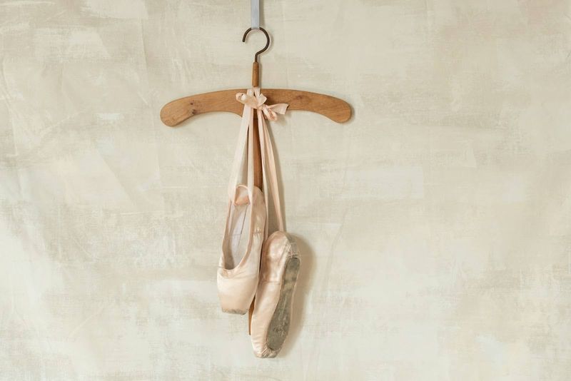 a pair of dance shoes hanging on a coat hangar