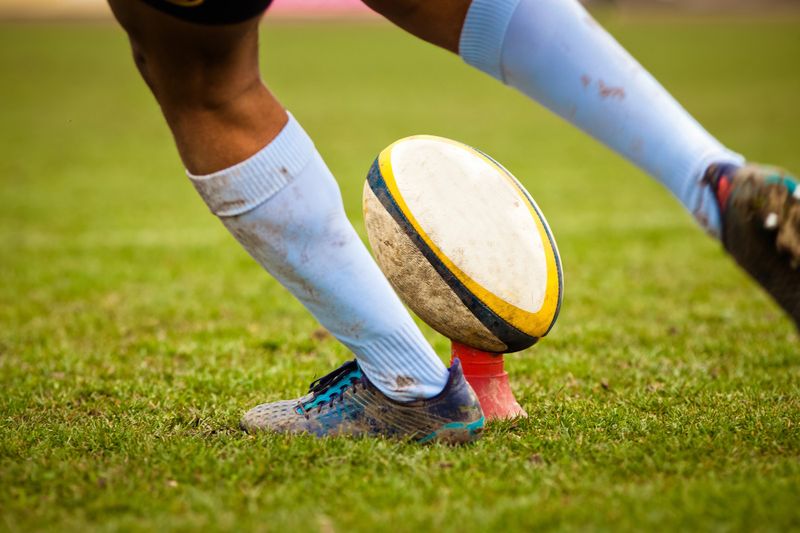 a rugby player about to kick a rugby ball