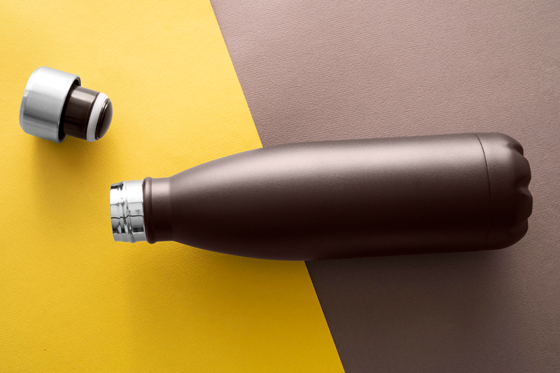 an insulated water bottle with the top separated on a yellow and brown background