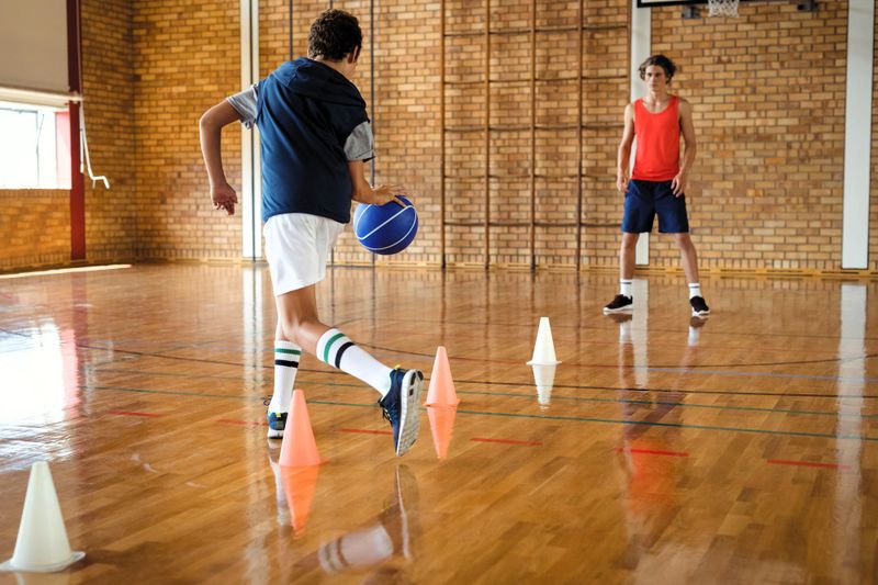 a young basketball player training using cones on a basketball court