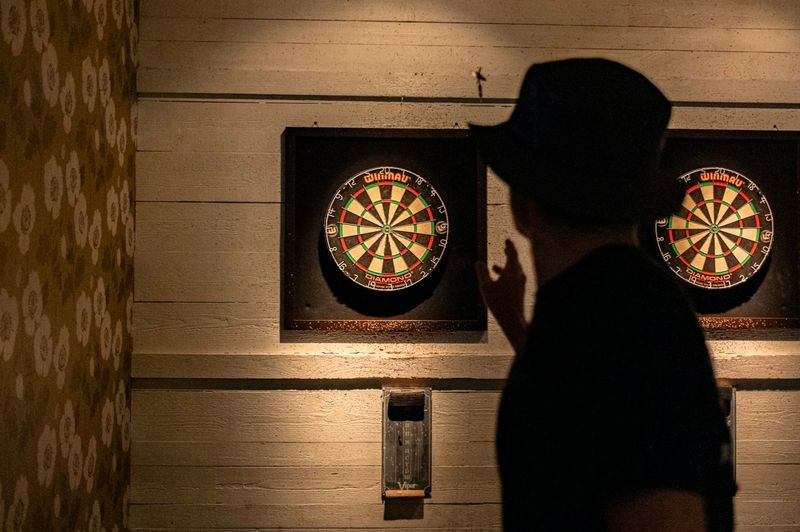 a man throwing a dart at a dart board