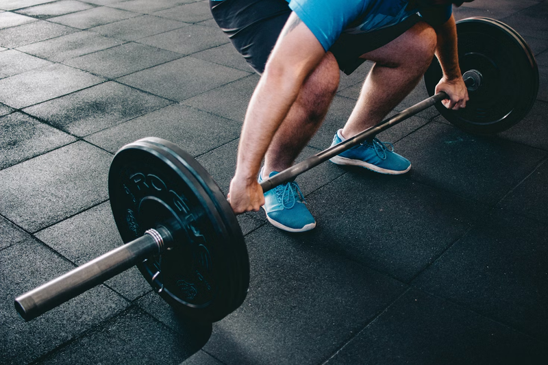 a man doing a deadlift with a barbell