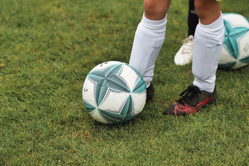 a soccer player wearing shin guards next to a soccer ball