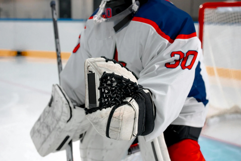 a hockey goalie standing in front of a goal