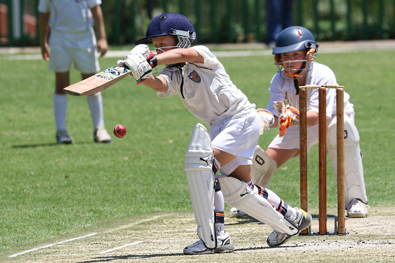 a youth cricket player batting the cricket ball