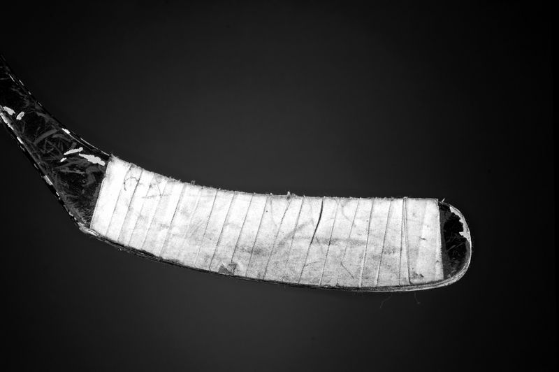 a close up shot of a hockey stick blade with hockey tape wrapped around the blade